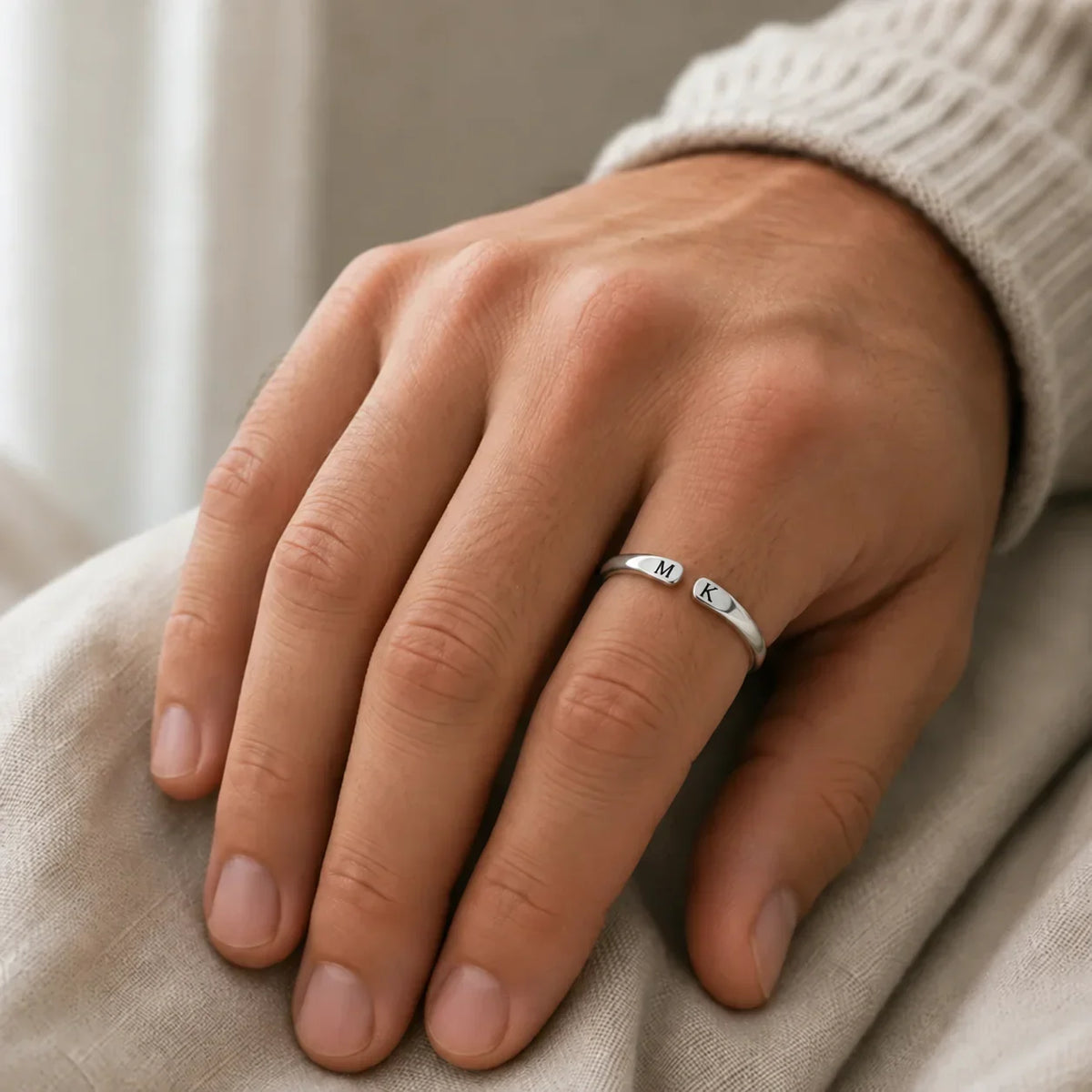 Anello con iniziali argentato indossato alla mano